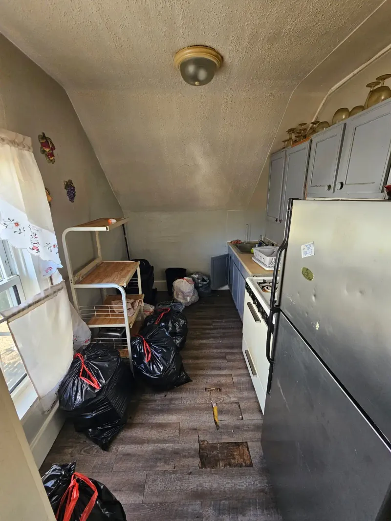 Kitchen cleanout with bagged debris and old appliances near Wareham