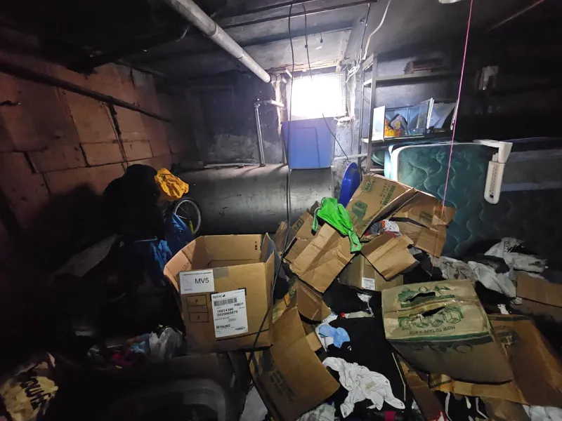 Basement overflowing with cardboard boxes and clutter before cleanout near Wareham